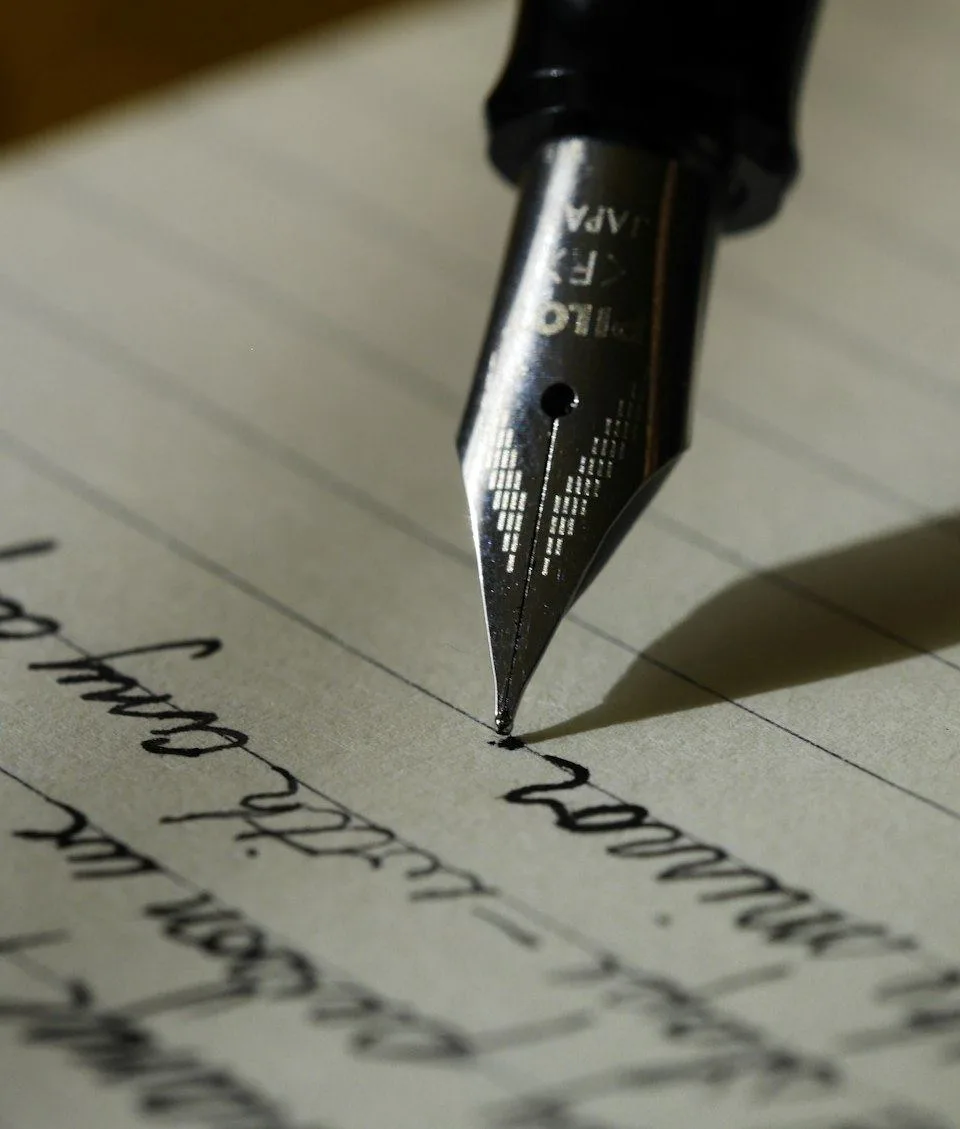 A fountain pen writing thoughts onto lined paper