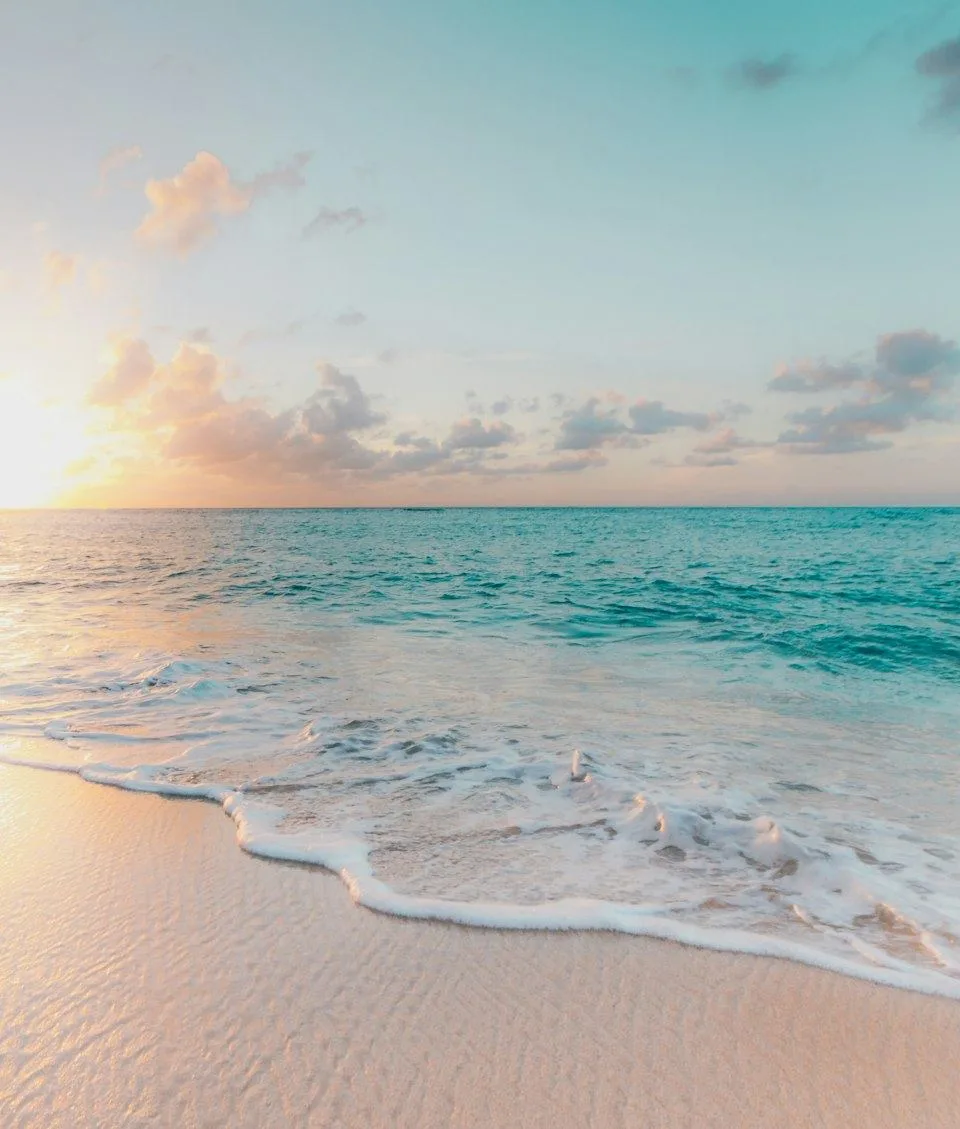 Gentle waves on a quiet beach at sunrise